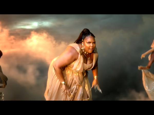 screenshot from rumors music video of lizzo bent over dancing in golden dress and bright shimmery highlighter